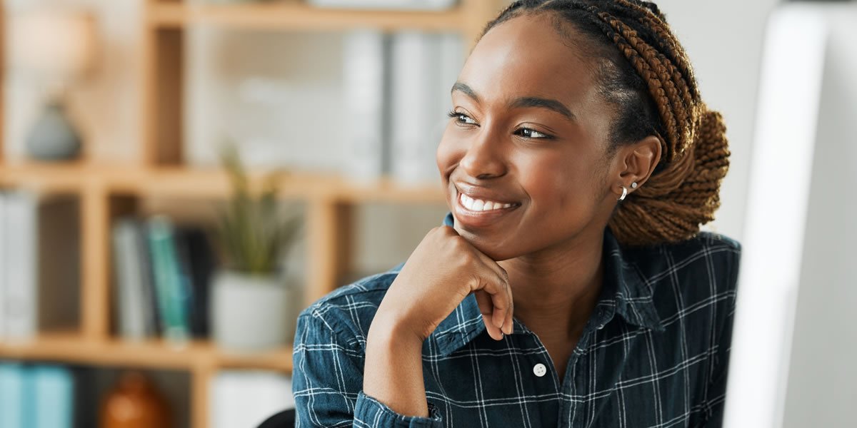 Student, woman thinking sat at computer